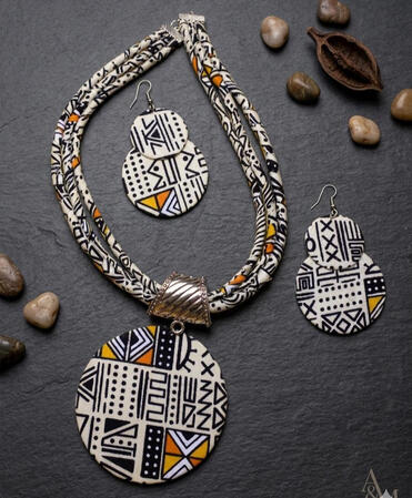 Nr. 3: Afro-Cuban Bogolan jewelry set featuring a circular pendant and earrings. Inspired by traditional patterns, this set combines cultural depth with modern design and expressive forms.