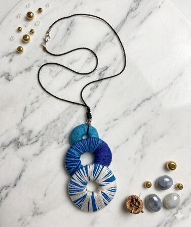 No. 1: A necklace featuring three circles in shades of blue. Timeless elegance for any occasion.